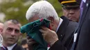 Presiden Palestina Mahmoud Abbas mencium bendera Palestina sebelum menaikkannya di markas besar PBB, New York, Rabu (30/9/2015). Sidang majelis Umum PBB menyetujui keputusan untuk mengibarkan bendera Palestina dan Vatikan. (REUTERS/Andrew Kelly)