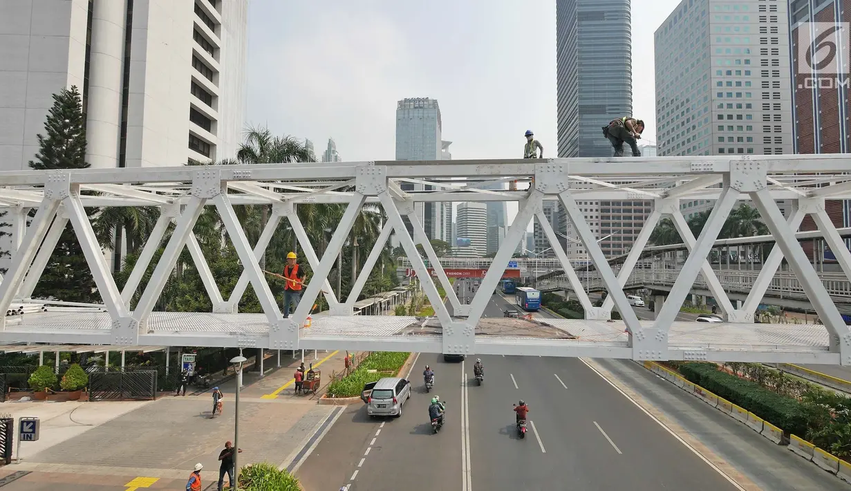 Pengendara melintas di bawah Jembatan Penyebrangan Orang (JPO) Dukuh Atas, Jakarta, Rabu (3/10). Rencananya Pemprov DKI Jakarta akan merelokasi JPO Dukuh Atas namun belum dapat dipastikan kapan dilaksanakan. (Liputan6.com/Herman Zakharia)