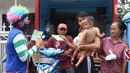 Komunitas Badut Tangerang  Raya (Batara) membagikan paket masker dan sabun cuci tangan gratis kepada warga di Larangan Selatan, Tangerang, Kamis (16/4/2020). PMI Kota Tangerang bersama Batara membagikan masker dan sabun cuci tangan untuk mencegah penyebaran COVID-19. (Liputan6.com/Angga Yuniar)