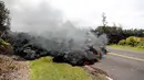 Pemandangan lava pijar erupsi Gunung Kilauea yang menutupi jalan di Hawaii, Amerika Serikat, Sabtu (5/5). Lembaga survei geologi Amerika Serikat (USGS) menyebut aliran lava pijar terjadi akibat retakan dinding kawah Gunung Kilauea. (AP Photo/Marco Garcia)