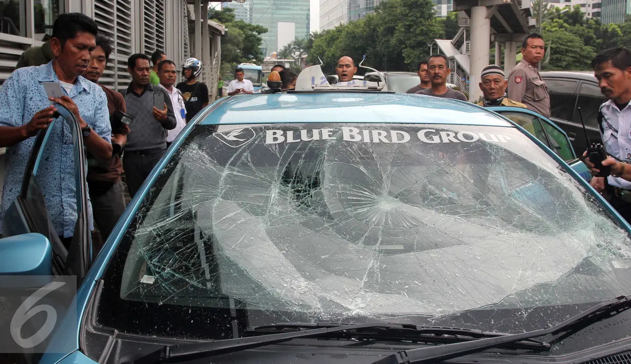 Sebuah taksi mengalami kerusakan usai diamuk massa di kawasan Kuningan, Jakarta, Selasa (22/3). Aksi anarkis ini adalah buntut dari demo yang dilakukan sejumlah sopir taksi. (Liputan6.com/Helmi Afandi)