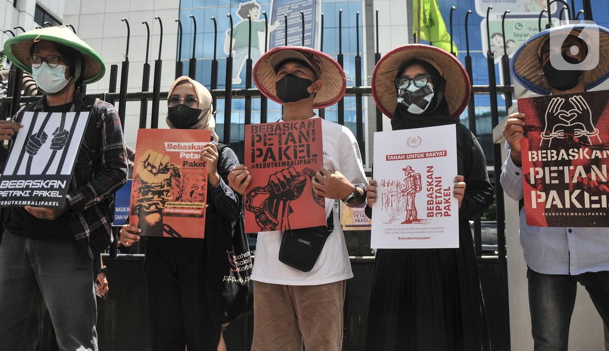 Aktivis Gerakan Rakyat untuk Kedaulatan Agraria membawa poster saat aksi mogok makan di depan Kantor Kementerian ATR/BPN, Jakarta, Senin (20/2/2023). Untuk menunjukkan aksi mogok makannya, mereka menggunakan masker dengan tanda silang hitam. (merdeka.com/Iqbal S Nugroho)