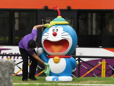 Seorang staf membersihkan dan mendisinfeksi patung Doraemon di pameran "Doraemon's Time-Travelling Adventures in Singapore" yang digelar di Museum Nasional Singapura pada 3 November 2020. Pameran ini akan berlangsung hingga 27 Desember 2020. (Xinhua/Then Chih Wey)