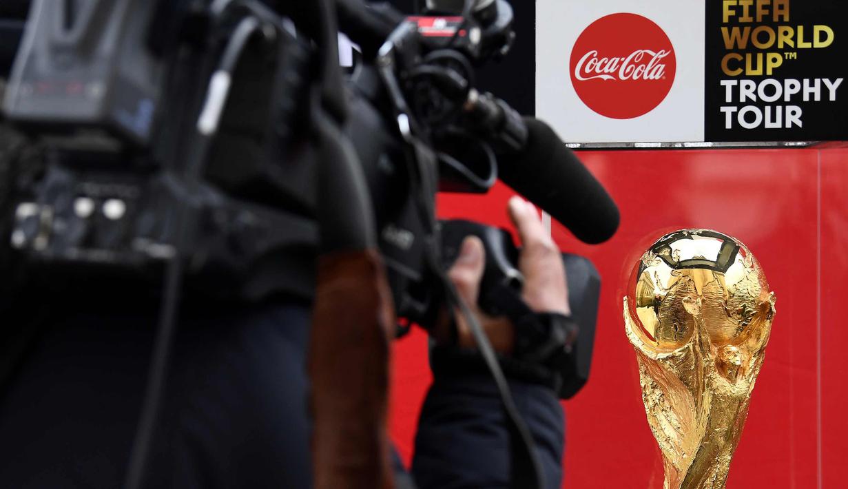 Seorang jurnalis mengambil gambar trofi FIFA World Cup saat FIFA World Cup Trophy Tour di Paris (20/3). Piala Dunia 2018 diselenggarakan 14 Juni dan 15 Juli 2018 di Rusia. (AFP Photo/Franck Fife)