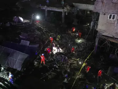 Para sukarelawan Palang Merah Lebanon mencari kemungkinan korban di sebuah bangunan yang hancur akibat serangan udara Israel di kota pelabuhan Sidon, Lebanon selatan, Selasa 6 Januari 2026 pagi waktu setempat. Sebuah serangan kembali menghantam wilayah Lebanon. (AP Photo/Mohammed Zaatari)