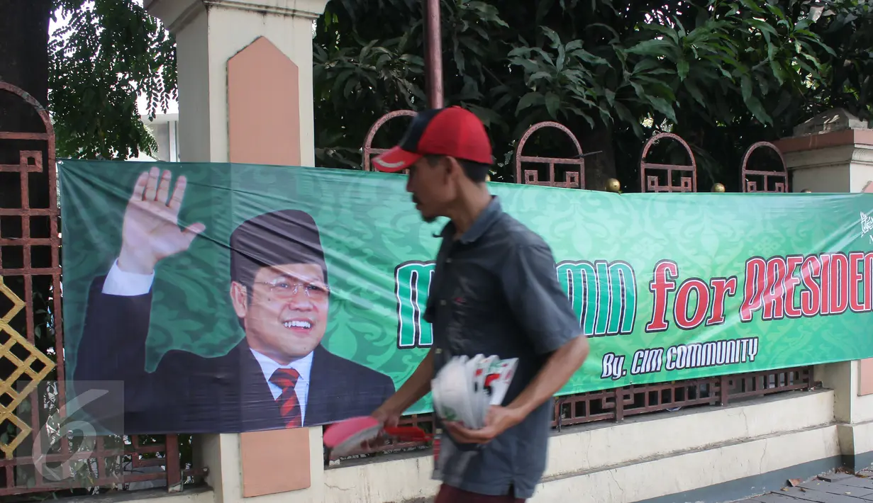 Warga berjalan melintasi spanduk bertuliskan 'Muhaimin for President' di pagar Masjid Sunda Kelapa, Jakarta, Sabtu (12/9). Pemasangan spanduk itu melanggar UU tentang larangan penggunaan tempat ibadah sebagai tempat kampanye. (Liputan6.com/Angga Yuniar)