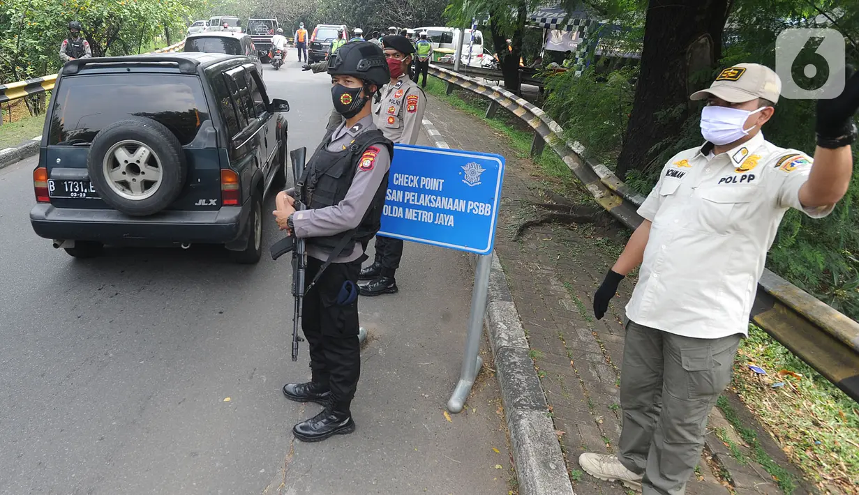 Angota Brimob bersama tim gabungan melakukan penyekatan kendaraan menuju Jakarta di Kelapa Dua, Jagakarsa, Jakarta Selatan, Rabu (27/05/2020). Masyarakat yang akan memasuki Jakarta wajib mempunyai Surat Izin Keluar Masuk (SIKM), jika tidak akan diminta putar balik. (merdeka.com/Arie Basuki)