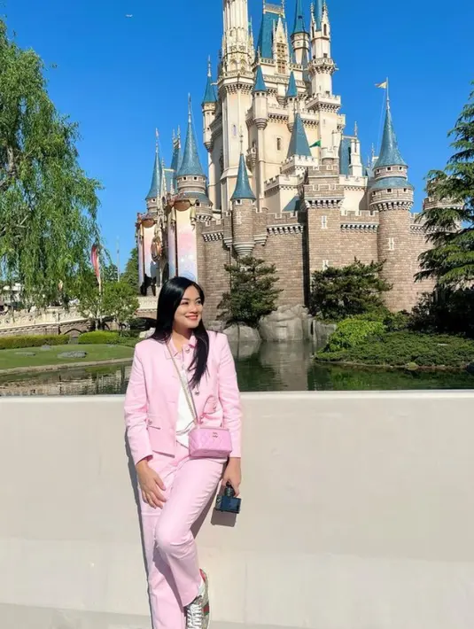 Ia juga tampil dengan atasan blazer pink dipadukan inner putih dan celana panjang pink serasi dengan tasnya.  [@titi_kamall]
