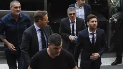Bintang Barcelona, Lionel Messi (kanan) dan ayahnya, Jorge Horacio Messi mendapat pengawalan ketat saat menuju pengadilan di Kantor Pengadilan Barcelona, (2/6/2016). (AFP/Josep Lago)