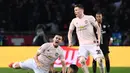 Andres Pereira dijatuhkan oleh Leandro Peredes pada leg kedua, babak 16 besar Liga Champions yang berlangsung di Stadion Parc des Princes, Paris, Kamis (7/3). Man United menang 3-1 atas PSG. (AFP/ Anne-Christine Poujoulat)