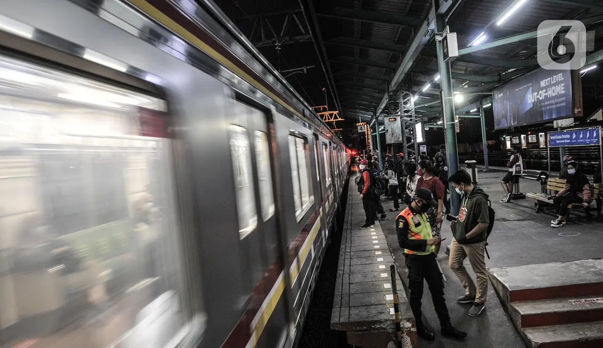 Penumpang menunggu kedatangan KRL di Stasiun Manggarai, Jakarta, Selasa (12/1/2021). Selama PSBB di DKI mulai 11-25 Januari, PT Kereta Commuter Indonesia (KCI) memangkas jadwal operasional KRL menjadi pukul 04.00 WIB hingga 22.00 WIB guna menekan penularan Covid-19. (merdeka.com/Iqbal Nugroho)