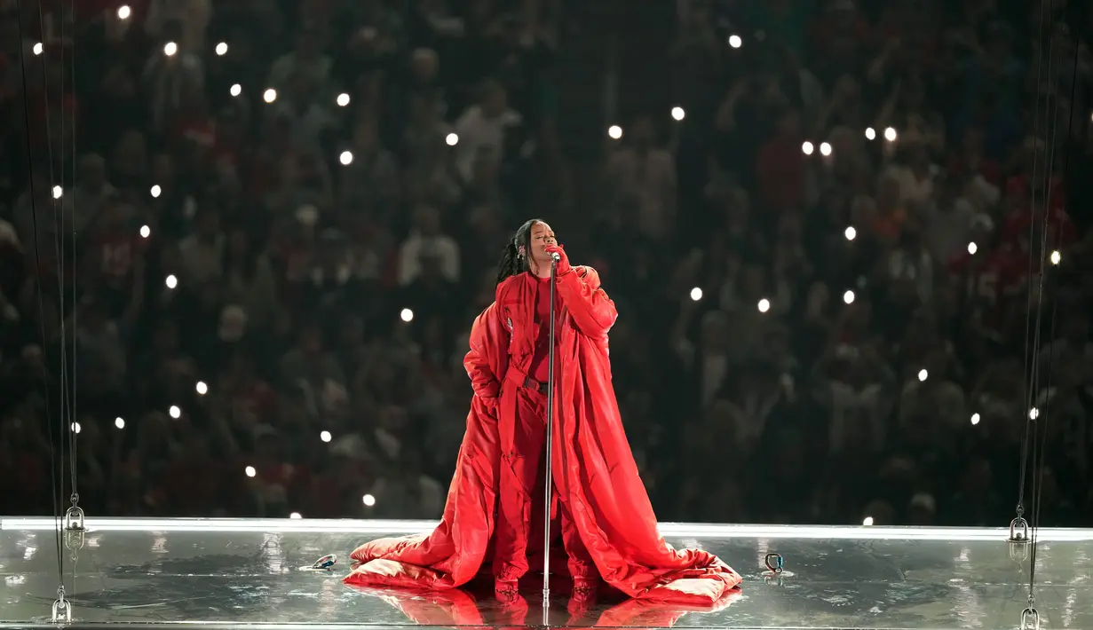 Rihanna tampil pada acara turun minum pertandingan sepak bola NFL Super Bowl 57 antara Kansas City Chiefs dan Philadelphia Eagles di Glendale, Arizona, Amerika Serikat, 12 Februari 2023. Penyanyi sekaligus pebisnis asal Barbados ini membawakan sederet hitsnya seperti "B*tch Better Have My Money", "Diamonds", hingga "Work". (AP Photo/Charlie Riedel)
