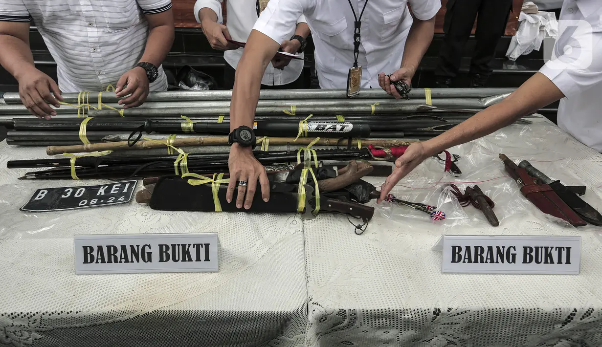 Polisi menata barang bukti saat rilis kasus premanisme kelompok John Kei di Polda Metro Jaya, Jakarta, Senin (22/6/2020). Dirkrimum Polda Metro Jaya menangkap 30 tersangka dan sejumlah barang bukti senjata tajam. (Liputan6.com/Johan Tallo)
