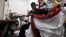Penjahit merapikan bendera Merah Putih di Pasar Senen, Jakarta, Kamis (2/8). Salah seorang penjahit mengaku pesanan bendera Merah Putih meningkat hingga 50 persen dibandingkan bulan-bulan sebelumnya. (Merdeka.com/Iqbal Nugroho)