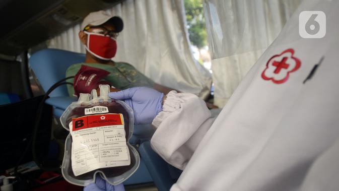Petugas Palang Merah Indonesia (PMI) mengambil darah pendonor di mobil donor darah keliling, Tangerang Selatan, Banten, Jumat (17/7/2020). PMI mengintensifkan pengoperasian mobil donor darah keliling untuk memenuhi persediaan stok darah saat pandemi COVID-19. (merdeka.com/Dwi Narwoko)