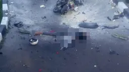 Seorang pria tergeletak di dekat sepeda motor dengan ceceran darah menyusul ledakan bom di halaman Polresta Surakarta, Solo, Jawa Tengah, Selasa (5/7). Bom diledakkan seorang pengendara motor yang berusaha menerobos masuk ke halaman Polresta. (Istimewa)