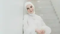 Pemain film Cinta Suci itu mengenakan gaun warna putih. Begitu pula dengan jilbabnya berwarna senada. (Instagram/_irishbella_).