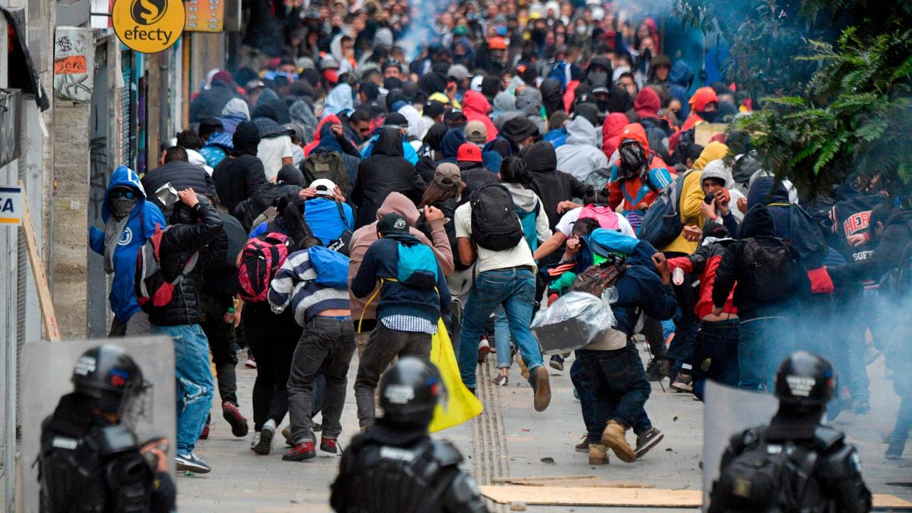 Para pengunjuk rasa dan polisi anti huru hara bentrok di Bogota, Kolombia, pada Jumat 22 November 2019. (AFP)