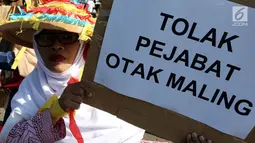 Massa membawa poster saat melakukan aksi menolak Revisi UU KPK di depan Gedung DPR/MPR RI, Jakarta, Rabu (11/9/2019). Mereka menyuarakan pro dan kontra terhadap revisi Undang-Undang Nomor 30 Tahun 2002 tentang Komisi Pemberantasan Tindak Pidana Korupsi. (Liputan6.com/Johan Tallo)