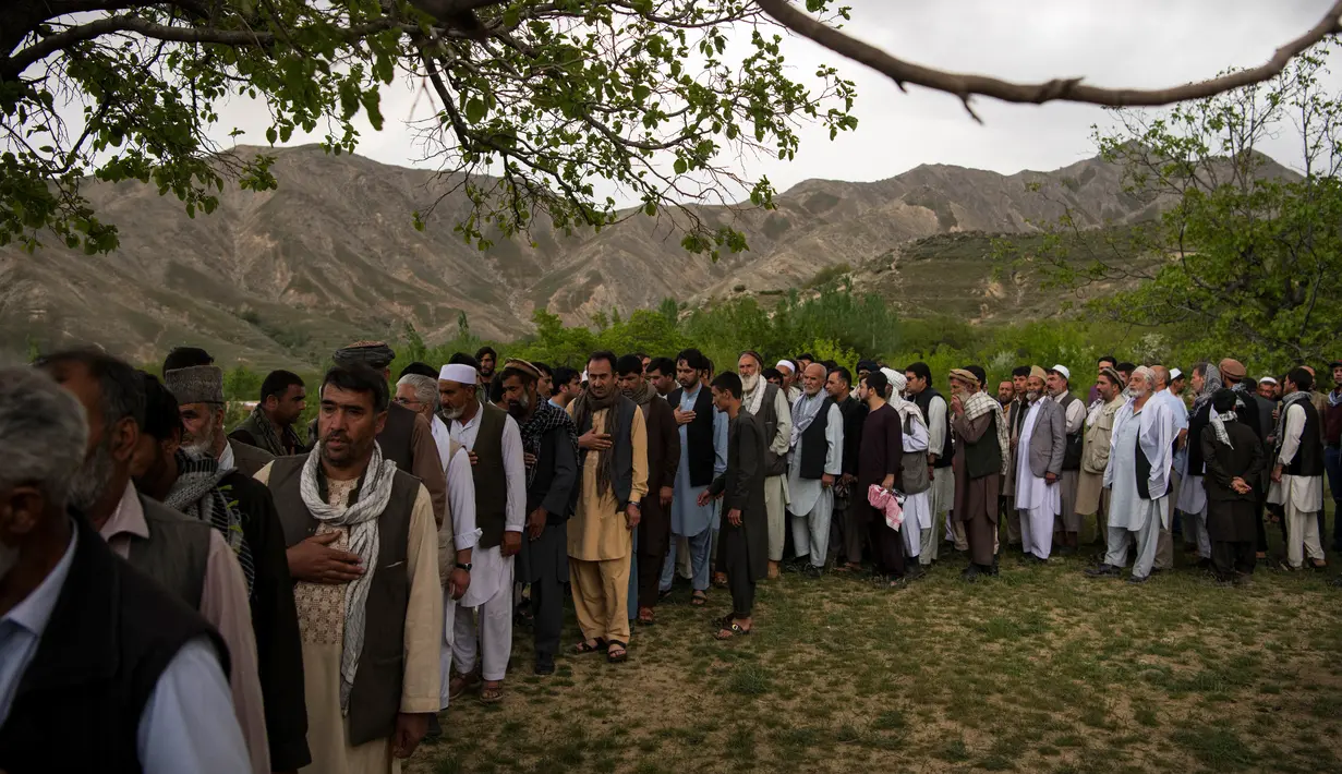 Teman dan kerabat menghadiri pemakaman jenazah kepala fotografer Agence France Presse (AFP) Afghanistan Shah Marai Faizi di Gul Dara, Kabul (30/4). Ledakan tersebut menewaskan 25 orang, di antara korban merupakan para wartawan.(Andrew Quilty / POOL / AFP)