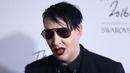 Pose Marilyn Manson saat menghidiri di Fashion Awards 2016 di London, Inggris (5/12). Mengenakan Jas dan kacamata hitam Marilyn Manson tampil keren saat menghadiri acara tersebut. (REUTERS/Neil Balai)