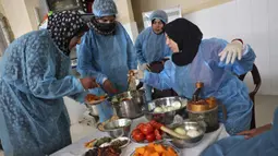 Para wanita membuat maftoul atau couscous di Khan Yunis, Jalur Gaza, Palestina, 10 Januari 2022. Maftoul dibuat dengan merebus gandum, lalu dijemur dan dipecahkan, kemudian digulung dengan tangan dan tepung terigu organik yang baru digiling, selanjutnya dikukus dan dijemur. (SAID KHATIB/AFP)