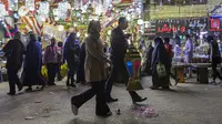 Seorang pria membawa lentera tradisional yang dibelinya jelang bulan suci Ramadhan di Distrik Sayyida Zeinab, Kairo, Mesir, 30 Maret 2022. Umat muslim Mesir memperketat dompet mereka jelang Ramadhan saat pengeluaran meningkat karena mata uang lokal kehilangan 17 persen nilainya. (Khaled DESOUKI/AFP)