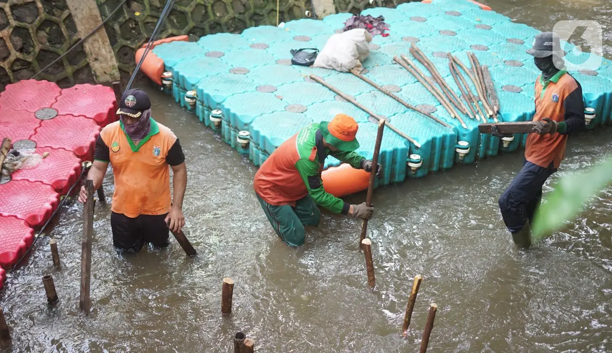 Petugas membuat jebakan sampah di Kali Pancoran, Jakarta, Kamis (12/11/2020). Jebakan sampah tersebut dibuat guna memermudah petugas saat membersihkan kali, terutama saat musim hujan. (Liputan6.com/Immanuel Antonius)