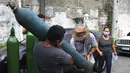 Anggota keluarga pasien COVID-19 yang dirawat di rumah sakit membawa tangki oksigen kosong untuk mengisinya kembali, di Manaus, negara bagian Amazonas, Brasil, 15 Januari 2021. Negara Bagian Amazonas di Brasil kehabisan oksigen karena semakin melonjaknya pasien Covid-19. (AP Photo/Edmar Barros)
