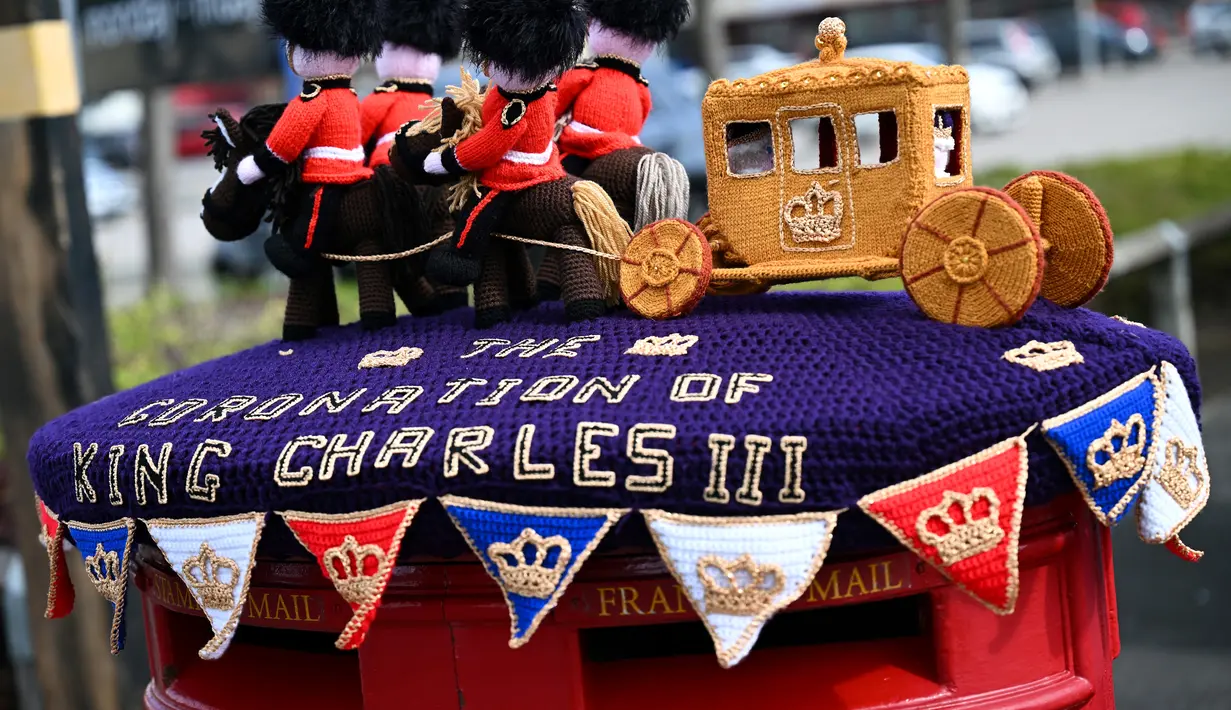 Sebuah foto yang diambil pada 2 Mei 2023 memperlihatkan kereta kuda rajutan yang dipajang di kotak pos di sebelahnya, menjelang penobatan Raja Charles III dan Permaisuri Camilla, di Rhyl, Wales utara. (Photo by Paul ELLIS / AFP)