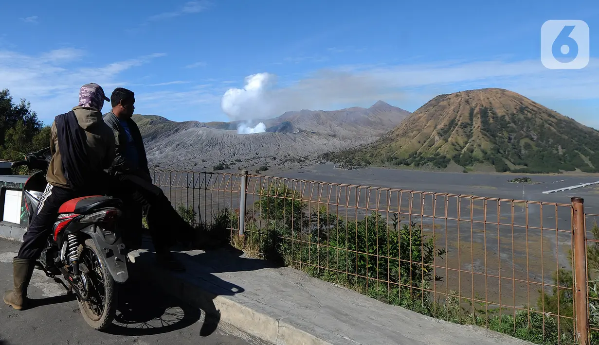 Dua pria melihat ke arah lautan pasir Gunung Bromo, Probolinggo, Jawa Timur, Jumat (10/9/2021). Balai Besar Taman Nasional Bromo Tengger Semeru (BB-TNBTS) mulai membuka pintu masuk kawasan wisata Bromo melalui Kabupaten Probolinggo. (merdeka.com/Arie Basuki)