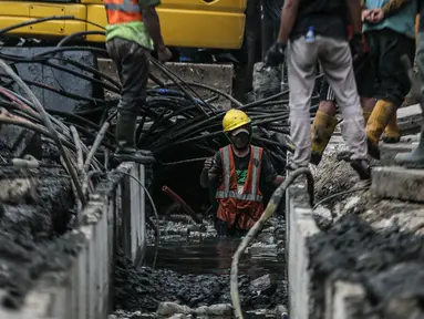 Pekerja menyelesaikan pembangunan trotoar atau pedestrian di kawasan Matraman Raya, Jakarta Timur, Sabtu (26/8/2023). (Liputan6.com/Faizal Fanani)
