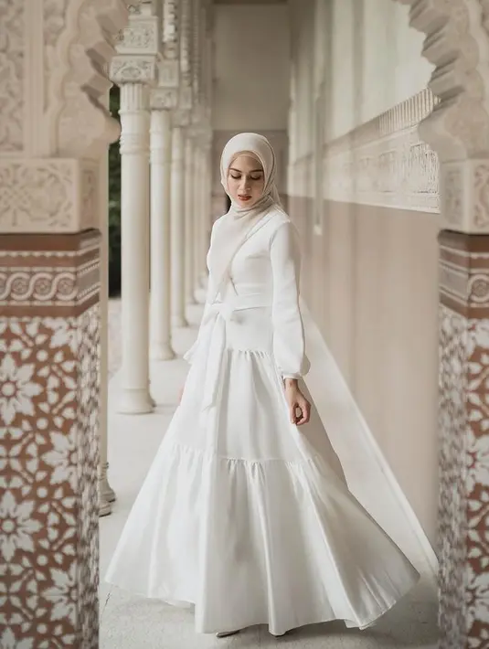 Nina Zatulini berkolaborasi dengan brand Atvezzo meluncurkan koleksi Raya. Ia mengenakan dress putih ruffle dengan belt. [@ninazatulini22]