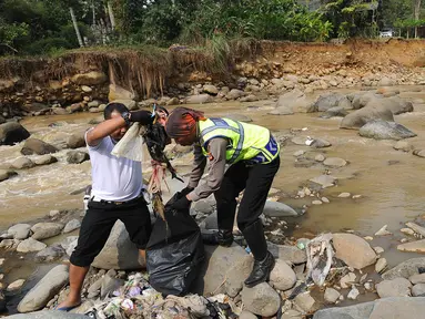 Dua Anggota Polantas Polres Bogor memungut sampah saat kegiatan aksi bersih sungai di kawasan aliran Sungai Ciliwung, gadog, Bogor (20/9). Aksi bersih sungai dalam rangka HUT lalu lintas ke-63. (Merdeka.com/Arie Basuki)
