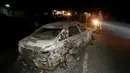 Sebuah mobil hangus terbakar usai terjadi tabrakan dengan mobil tangki pembawa gas kimia di Kenya, Minggu (11/12). Dikabarkan lebih dari 30 orang tewas dalam peristiwa nahas tersebut. (REUTERS / Stringer)