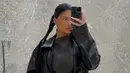 Dengan caption "date night," Kylie Jenner mengunggah foto selfienya dengan outfit serba hitam. Mini dress hitam, ditumpuknya dengan long coat kulit berwarna hitam. Ia juga mengepang rambutnya. Foto: Instagram.