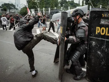 Pengunjuk rasa berusaha menghalangi polisi yang maju dengan perisai selama demonstrasi yang menuntut pembubaran parlemen di depan gedung parlemen Dewan Perwakilan Rakyat di Jakarta pada 25 Agustus 2025. (YASUYOSHI CHIBA/AFP)