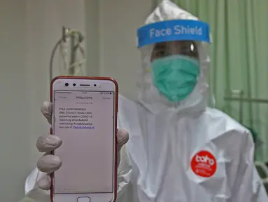 Tenaga kesehatan menunjukkan pesan singkat penerima vaksin COVID-19 di RSIA Tambak, Jakarta, Selasa (5/01/2021). Kementerian Kesehatan mengirimkan Short Message Service (SMS) blast secara serentak kepada penerima vaksin COVID-19 tahap pertama pada Kamis (31/12) lalu. (Liputan6.com/Herman Zakharia)