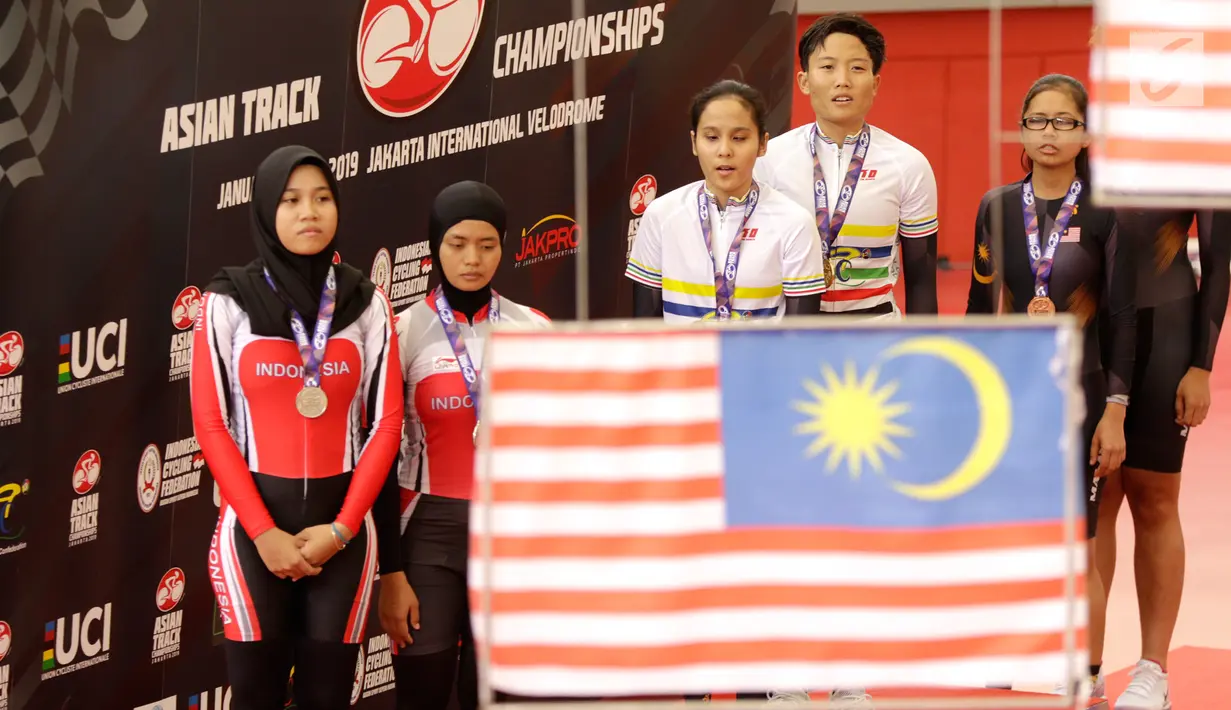Pesepeda Indonesia Ni'mal Magfiroh dan Sri Sugiyanti mengikuti seremoni medali nomor 3.000 meter persuit individu B saat Asian Track Championship 2019 di Veledrome, Jakarta, Jumat (11/1). Pasangan ini berhasil meraih perak. (Bola.com/Yoppy Renato)