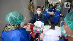 Petugas Kelompok Penyelenggara Pemungutan Suara (KPPS) menjalani rapid test Covid-19 di kantor Kelurahan Pondok Benda, Tangerang Selatan, Jumat (27/11/2020). Rapid Test tersebut diikuti 1.017 anggota KPPS serta Petugas Pengamanan Tempat Pemungutan Suara (PAM TPS). (merdeka.com/Dwi Narwoko)