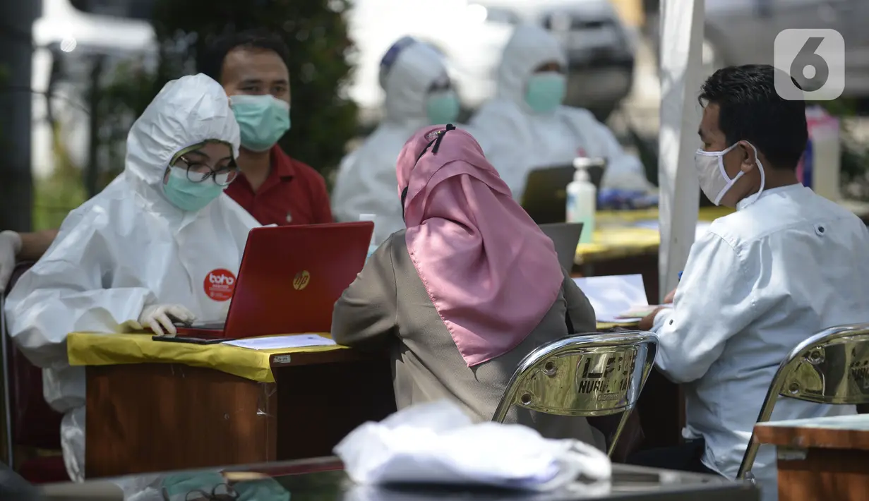 Petugas Puskesmas mendata warga yang mengikuti swab test di Balai RW 20, Villa Dago, Pamulang, Tangerang Selatan, Banten, Jumat (17/7/2020). Swab test gratis yang digelar seiring meningkatnya kasus COVID-19 tersebut diikuti 200 warga dari beberapa RW di Benda Baru. (merdeka.com/Dwi Narwoko)