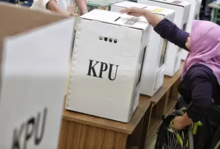 Penyandang disabilitas memasukkan surat suara ke dalam kotak saat simulasi Pemilu di Jakarta, Kamis (14/2). KPU menyediakan sejumlah fasilitas di TPS untuk penyandang disabilitas. (Liputan6.com/Faizal Fanani)