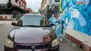Sejumlah staf medis mengambil sampel usap (swab) dari para penumpang kendaraan untuk tes COVID-19 di Shah Alam, Negara Bagian Selangor, Malaysia (12/12/2020). Malaysia melaporkan 1.937 kasus baru COVID-19, menambah total kasus di negara tersebut menjadi 82.246. (Xinhua/Chong Voon Chung)