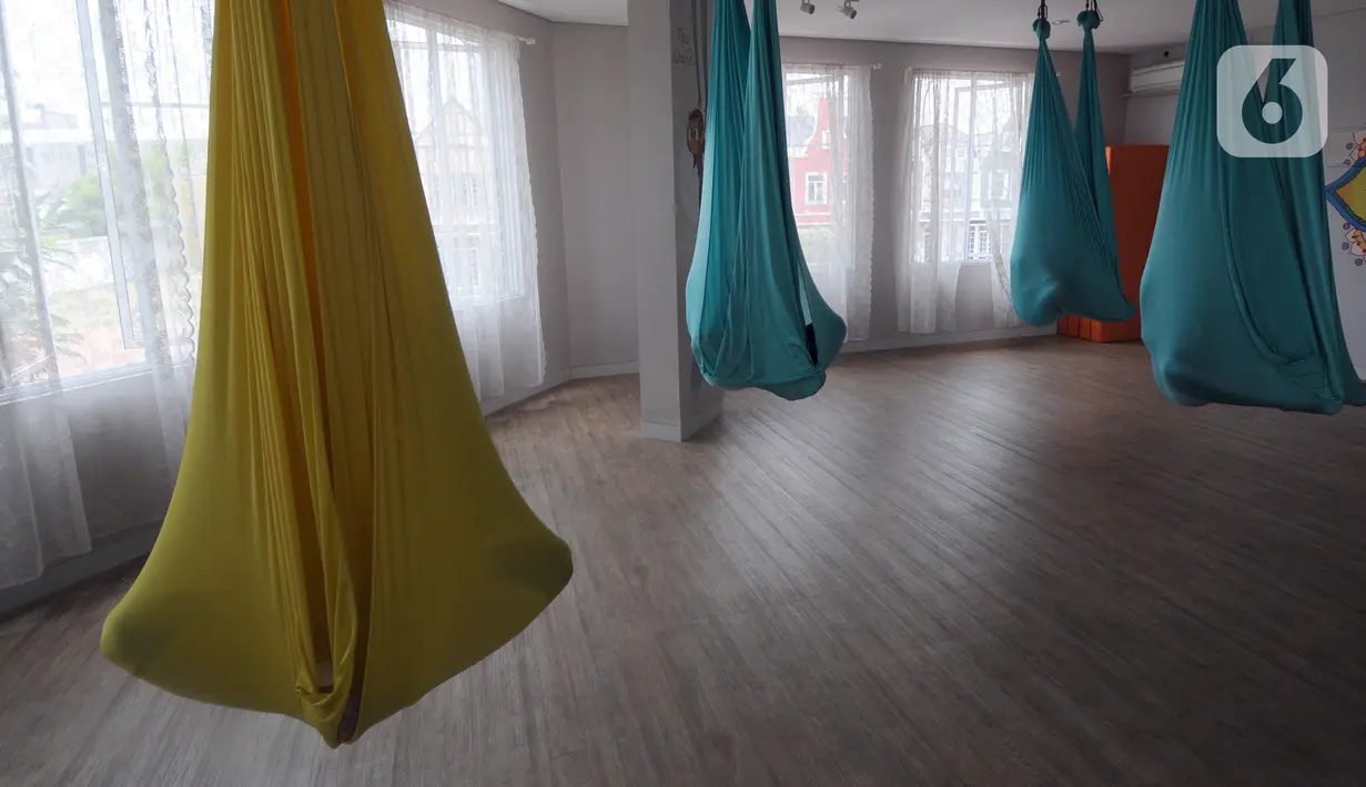 Para murid melakukan gerakan aerial yoga atau yoga udara di Aerial Jooga Studia, Kelapa Dua, Tangerang, Banten, Minggu (10/10/2021). Di masa pandemi, peminat olahraga yang berasal dari Amerika Serikat ini meningkat lebih dari 60 persen. (merdeka.com/Arie Basuki)