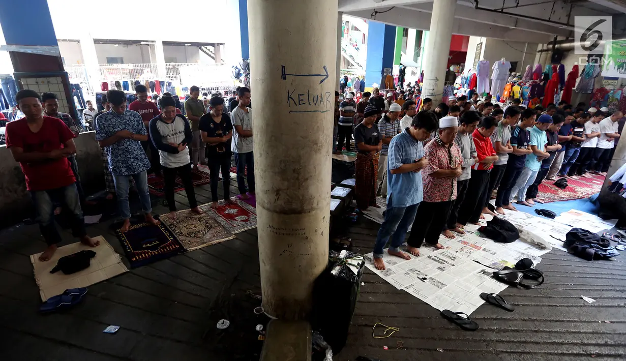 Umat muslim melakukan salat Jumat diantara kios-kios Pedagang Tanah Abang, Jakarta, Jumat (9/6). Dikarenakan membeludaknya jamaah yang ingin beribadah mereka terpaksa melakukan salat di antara kios-kios pasar. (Liputan6.com/Johan Tallo)
