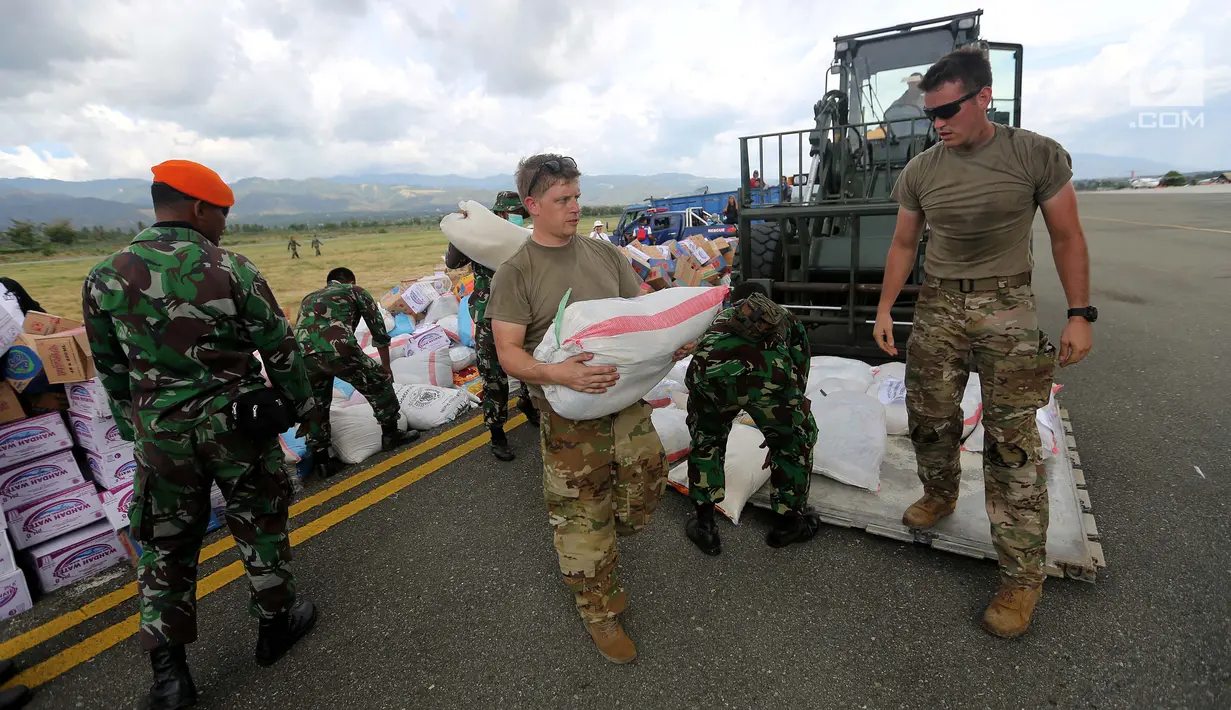 Tentara Amerika Serikat mendistribusikan bantuan logistik yang tiba di Bandara Mutiara Sis Al-Jufri, Palu, Sulawesi Tengah, Minggu (7/10). Tentara AS membantu mendistribusikan dari landasan menuju bandara. (Liputan6.com/Fery Pradolo)