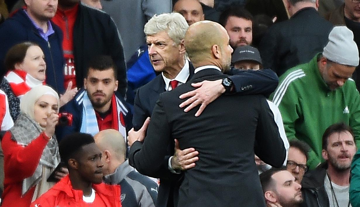 Pelatih Arsenal, Arsene Wenger dan Pelatih Manchester City, Pep Guardiola berpelukan usai laga berakhir. Hasil itu membuat Manchester City tetap berada di peringkat keempat sementara Arsenal menduduki posisi keenam. (EPA/Andy Rain)