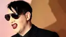 Rocker, Marilyn Manson berpose saat menghidiri di Fashion Awards 2016 di London, Inggris (5/12). Mengenakan Jas dan kacamata hitam Marilyn Manson tampil keren saat menghadiri acara tersebut. (REUTERS/Neil Balai)