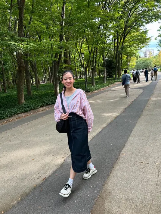 Hal ini terlihat juga dalam momen liburannya sekaligus pulang ke kampung halaman di Jepang. Salah satu foto memperlihatkan Haruka yang tengah berjalan santai tampil fresh dengan padanan kemeja warna pink, grey top, dan rok midi denim.