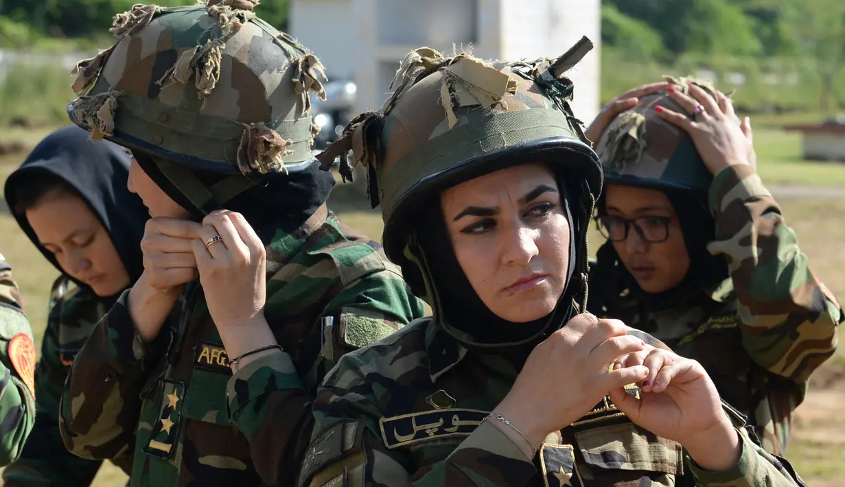 Kadet tentara wanita Afghanistan memakai helm sebelum mengikuti program latihan militer di Akademi Pelatihan Perwira di Chennai, India (12/12/2019). Sebanyak dua puluh kadet tentara Afghanistan mengikuti program latihan militer tersebut. (AFP/Arun Sankar)